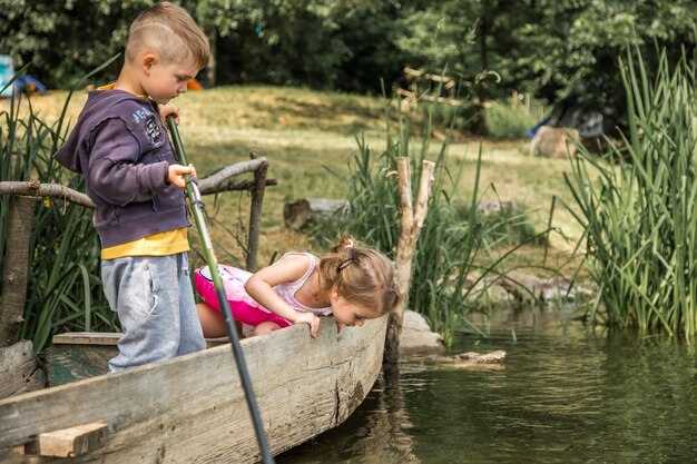 Niño niña pescando en un bote