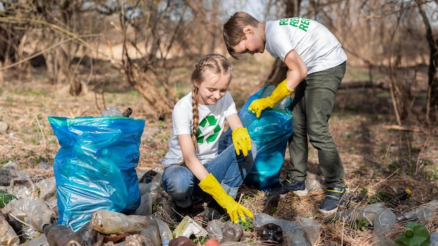 Niño y niña en la recolección de basura plástica