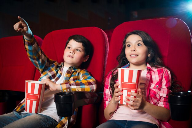 Niño y niña viendo película en el cine