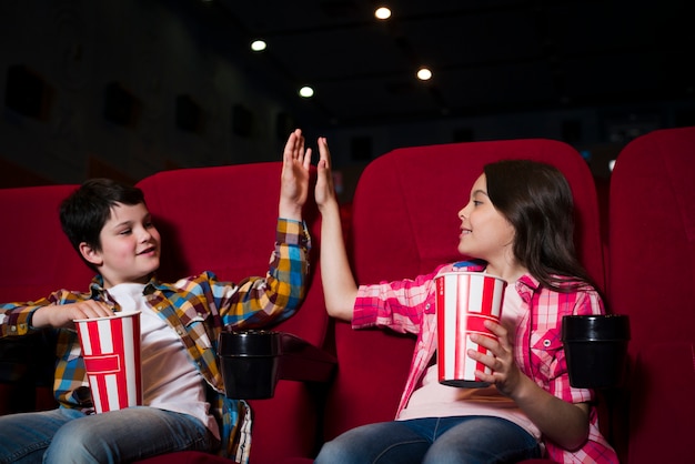 Niño y niña viendo película en el cine