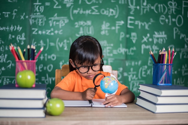 Foto gratuita niño observando o estudiando el modelo de globo educativo en el aula.