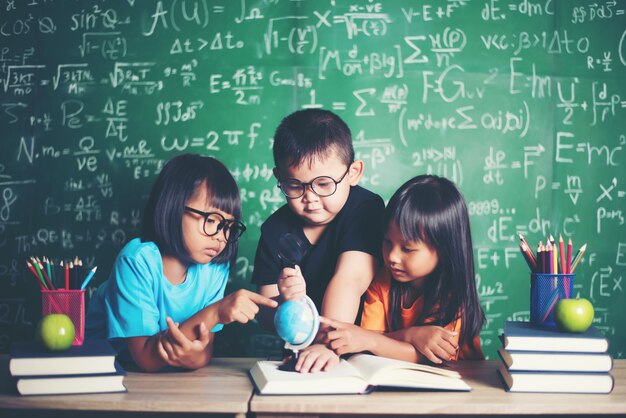 niño observando o estudiando el modelo de globo educativo en el aula.