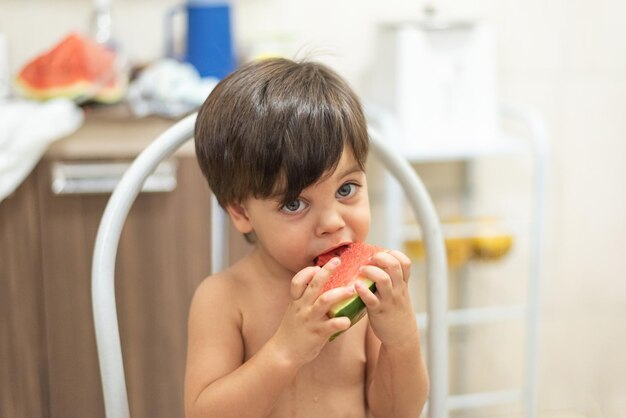 Niño de ojos azules comiendo sandía