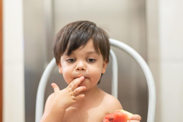 Niño de ojos azules comiendo sandía