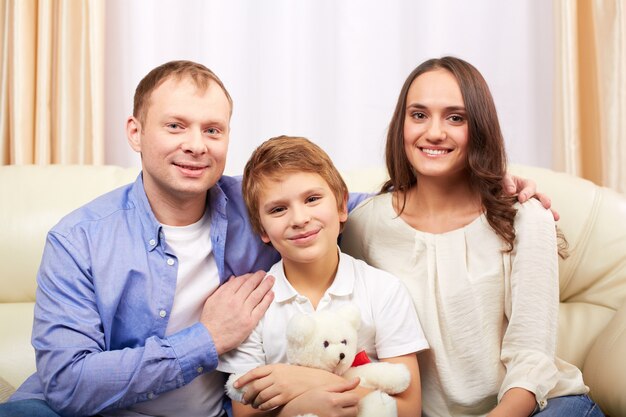 Niño con oso de peluche y sus padres