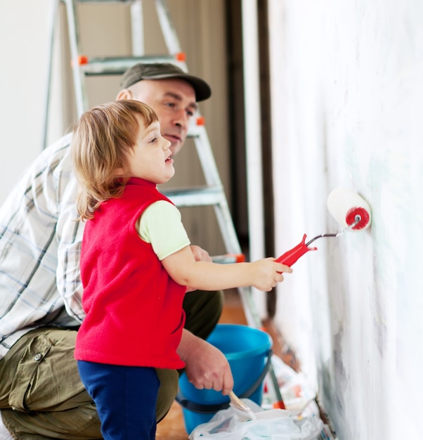 Foto gratuita niño con el padre pinta la pared