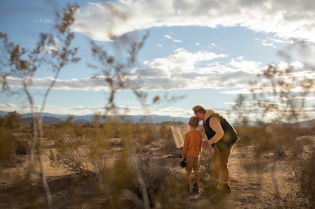 Foto gratuita niño y padre de tiro completo en el desierto