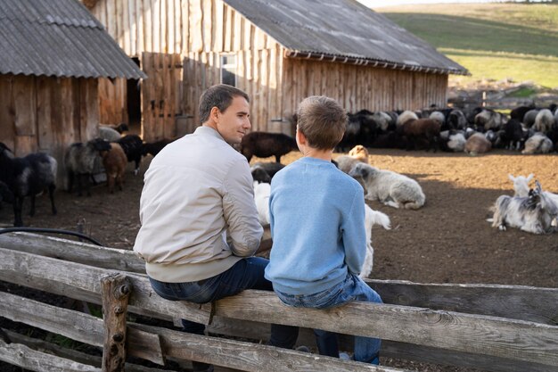 Niño y padre de tiro completo sentados juntos