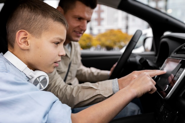 Niño y papá cerca de un coche eléctrico.