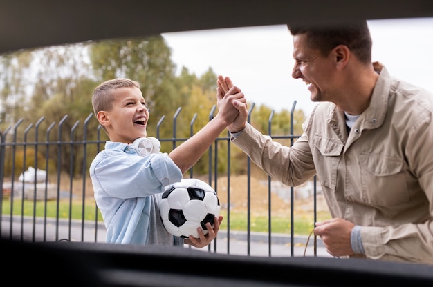 Niño y papá cerca de un coche eléctrico.