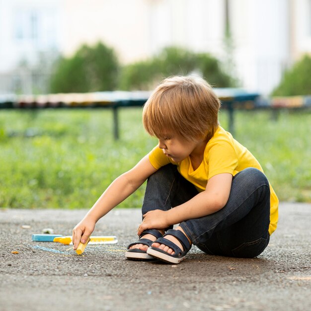 Niño en el parque de dibujo con tiza