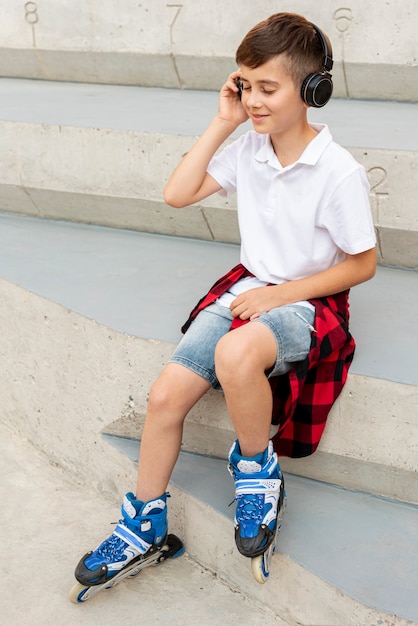Niño con patines en línea y auriculares
