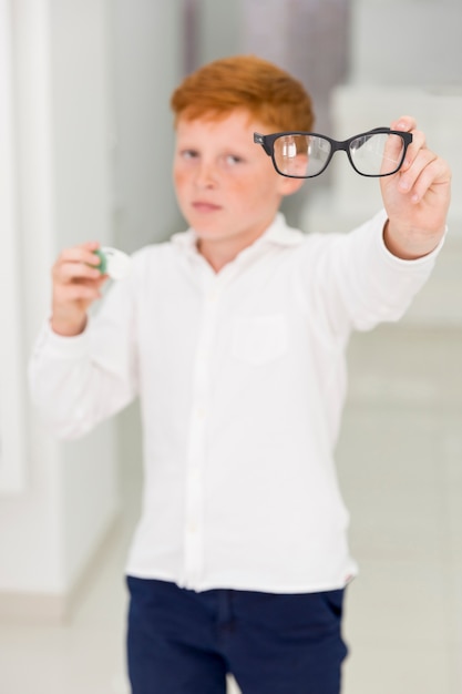 Foto gratuita niño de pecas con lentes y lentes de contacto