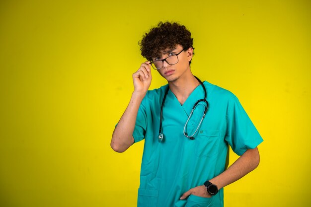 Niño de pelo rizado en uniforme médico con estetoscopio