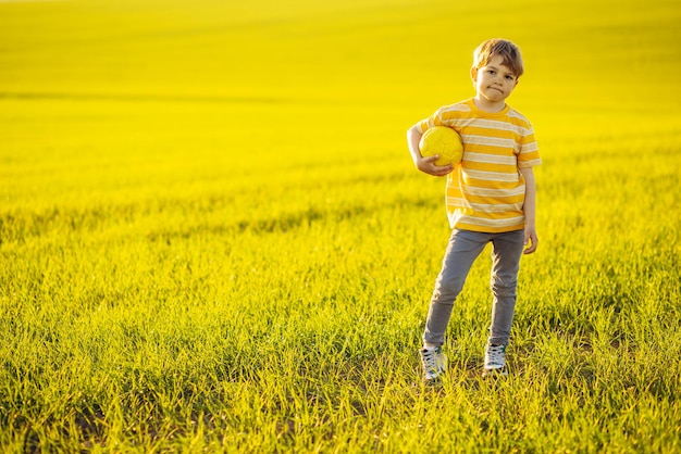 niño, con, pelota de fútbol, en, el, pradera