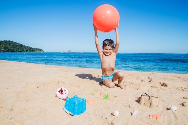 Niño con pelota en la playa