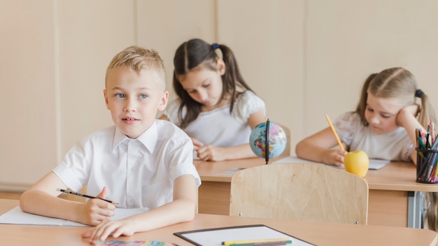 Foto gratuita niño pensando y mirando a otro lado durante la lección