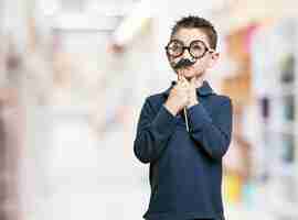 Foto gratuita niño pensativo con gafas y bigote