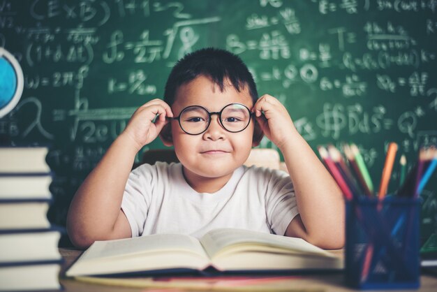 Niño pensativo con el libro en el aula