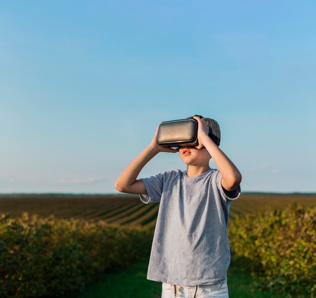 Niño pequeño adorable divirtiéndose con gafas de realidad virtual