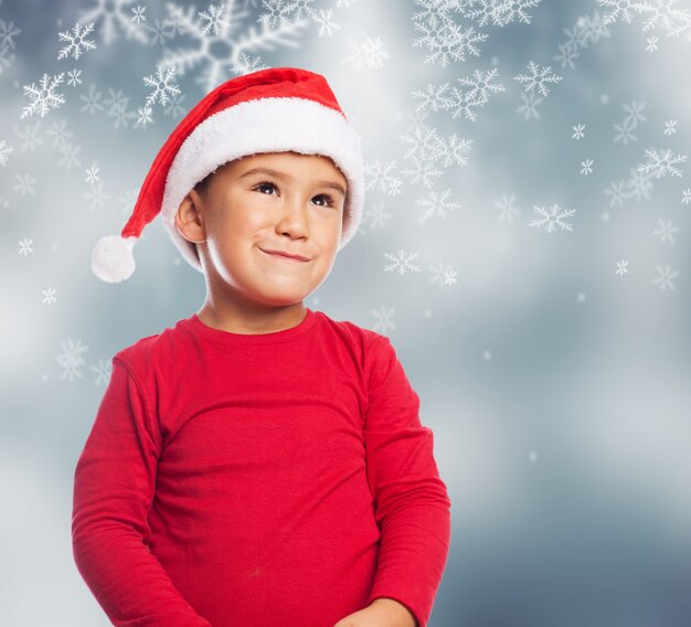 Niño pequeño alegre con copos de nieve de fondo