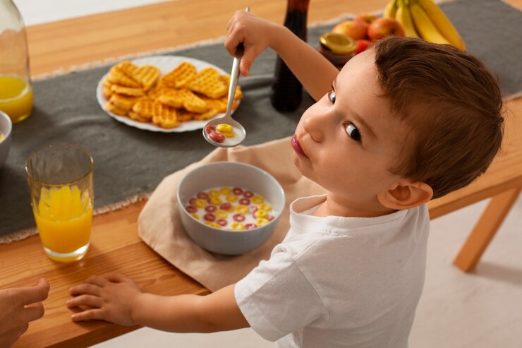 Foto gratuito niño pequeño de alto ángulo comiendo