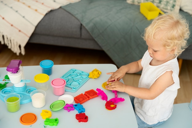 Niño pequeño de alto ángulo jugando en el interior