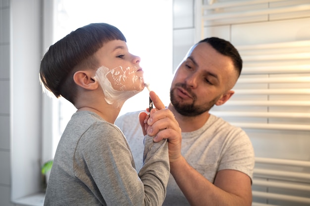 Foto gratuita niño pequeño aprendiendo a afeitarse vista lateral