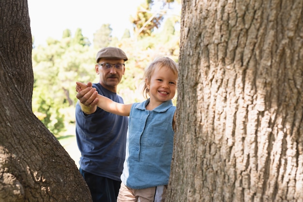 Niño pequeño en los árboles con el abuelo