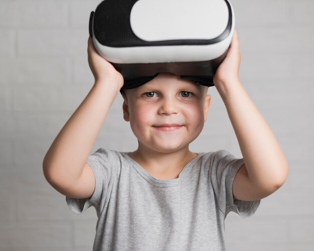 Foto gratuita niño pequeño con auriculares virtuales en