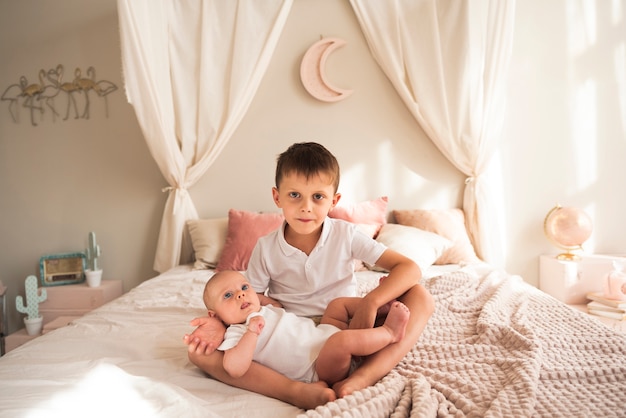 Niño pequeño con bebé recién nacido