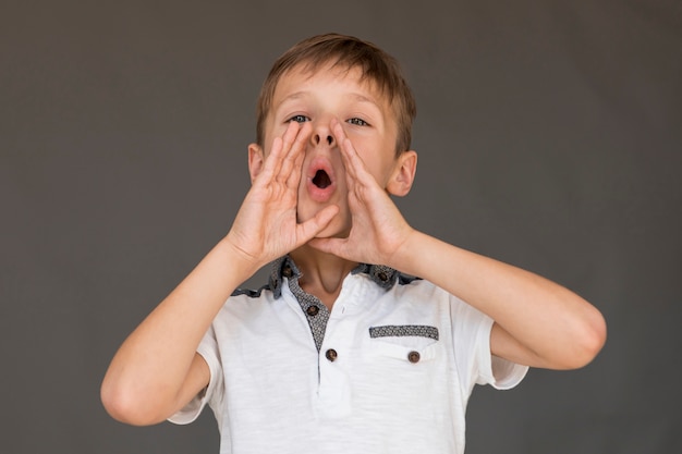 Niño pequeño en camiseta blanca gritando