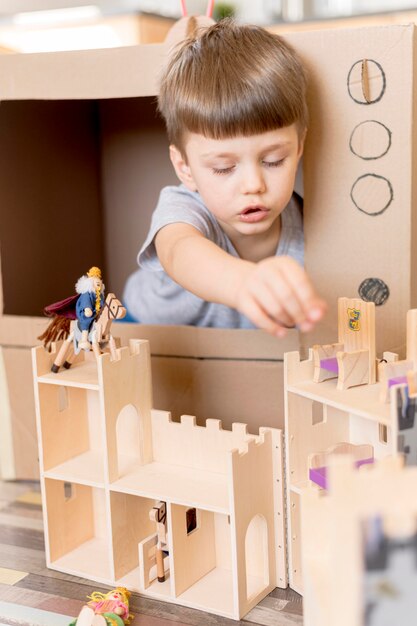 Niño pequeño con castillo de madera