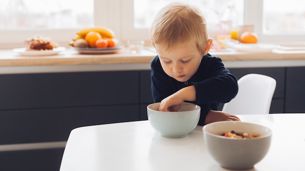 Foto gratuita niño pequeño cogiendo cereales