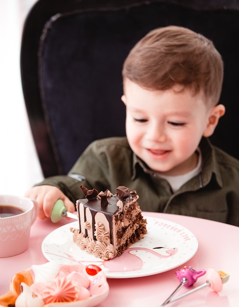 Niño pequeño come pastel de chocolate