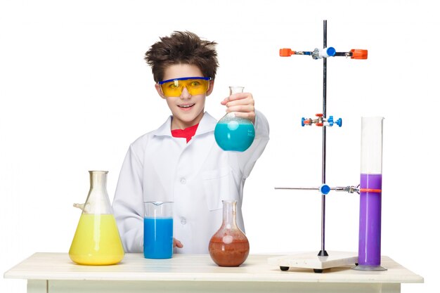Niño pequeño como químico haciendo experimento con fluido químico en el laboratorio