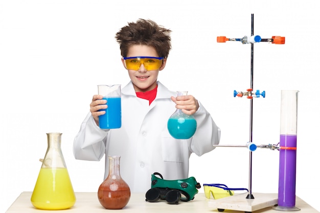 Niño pequeño como químico haciendo experimento con fluido químico en el laboratorio