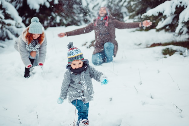 El niño pequeño corriendo a lo largo de la nieve