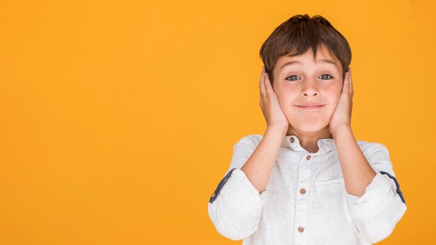 Niño pequeño cubriendo sus oídos con espacio de copia