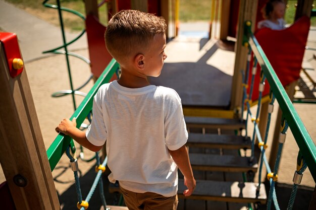 Niño pequeño divirtiéndose en el patio de recreo al aire libre