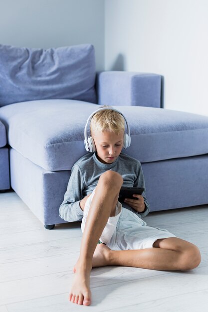 Niño pequeño divirtiéndose con tablet y auriculares