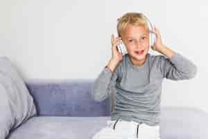 Foto gratuita niño pequeño escuchando música en casa