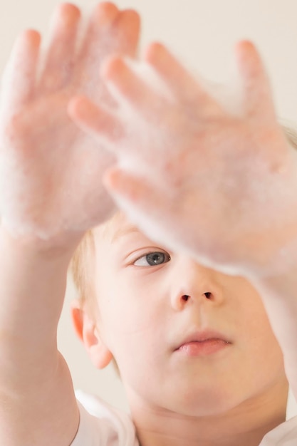 Foto gratuita niño pequeño con espuma en las manos