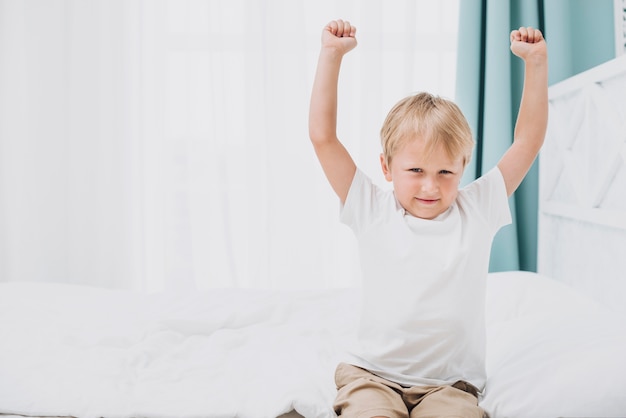 Niño pequeño estiramiento después de despertarse