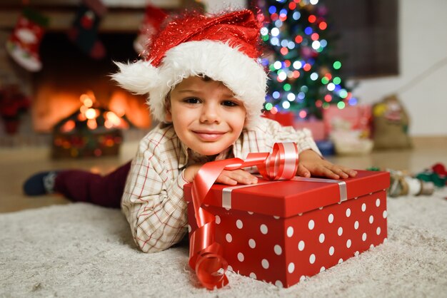 Niño pequeño feliz vistiendo el sombrero de papa noel