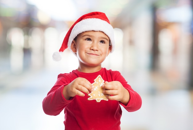 Niño pequeño con una galleta de árbol