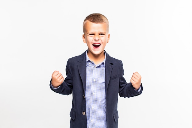 Niño pequeño con gesto ganador aislado en la pared blanca