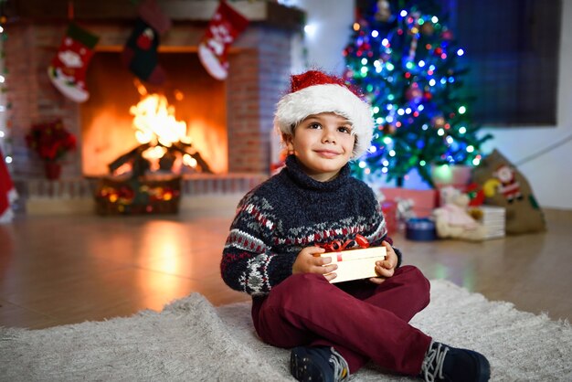 Niño pequeño en una habitación decorada para navidad