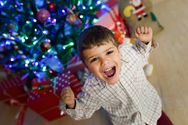 Niño pequeño en una habitacion decorada para navidad