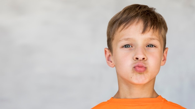 Niño pequeño haciendo una cara tonta con espacio de copia